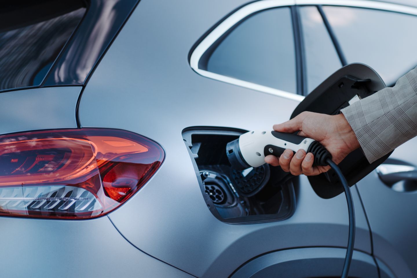photo of person charging an electric vehicle
